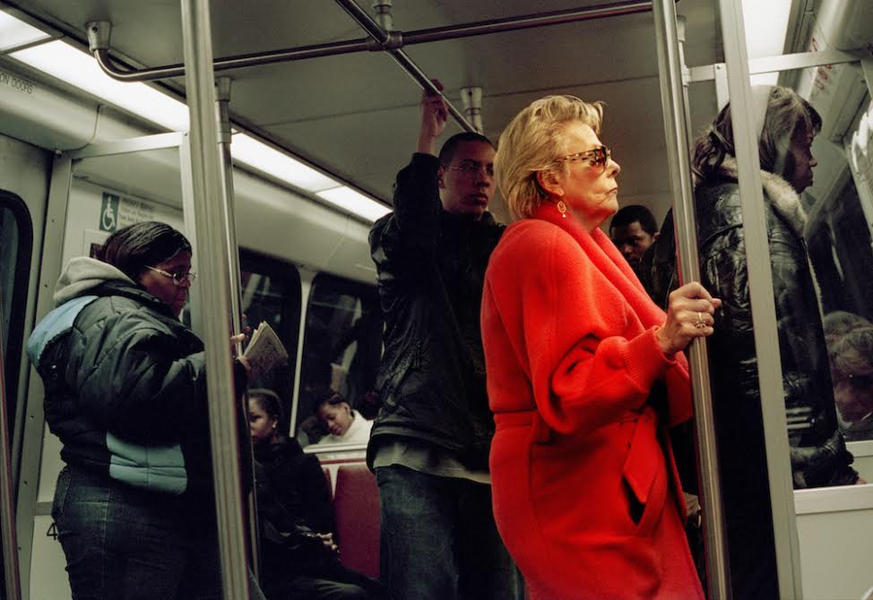 April 2006: A woman in a red coat stands on a Metro train in Washington DC.