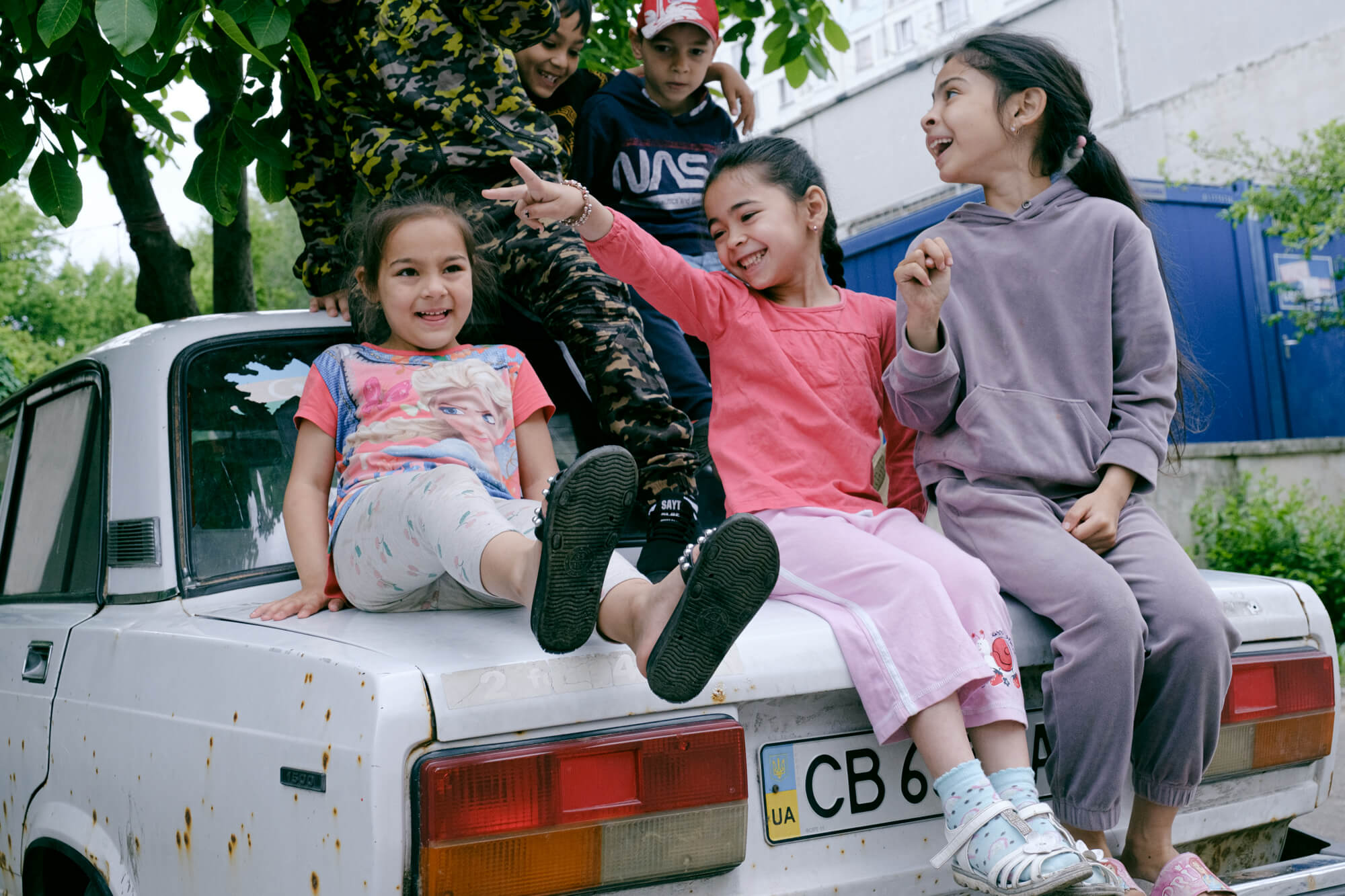 Діти бавляться на машині українського біженця. У цьому центрі в дітей рідко бувають уроки, тож здебільшого вони грають