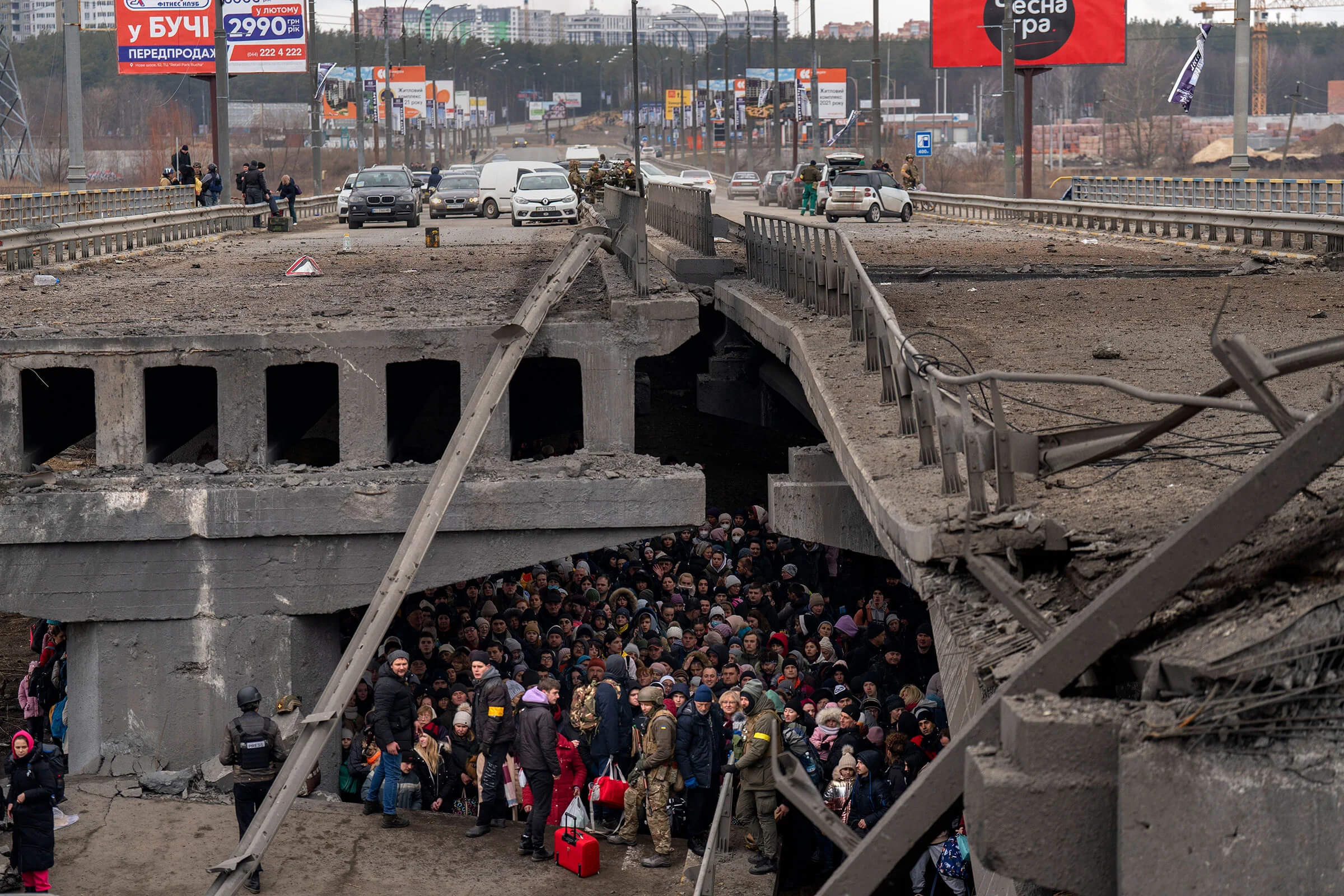 Українці стоять під зруйнованим мостом, намагаючись втекти через річку Ірпінь, Київська область, Україна, 5 березня. Фото: Еміліо Морнатті  для AP