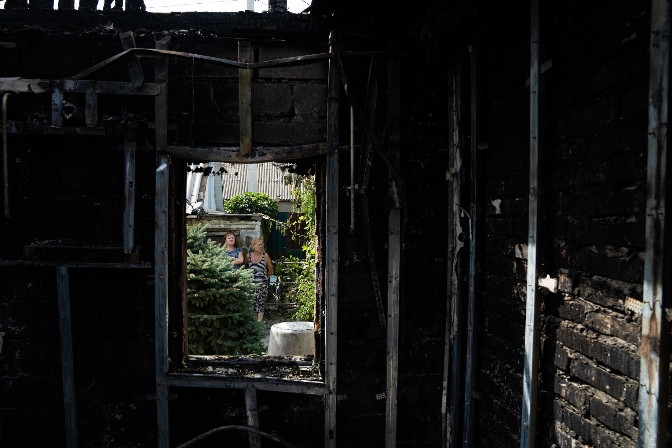 Люди дивляться на будинок, зруйнований внаслідок обстрілу російськими військами. Нікополь, 22 серпня 2022 року.
