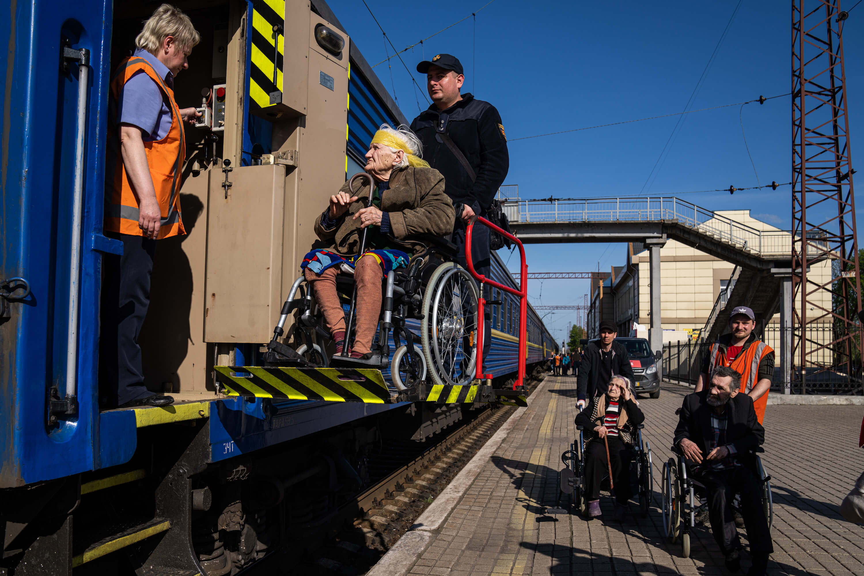 Рятувальник допомагає літній жінці з інвалідністю сісти на евакуаційний потяг. Покровськ, 26 квітня 2022 року.