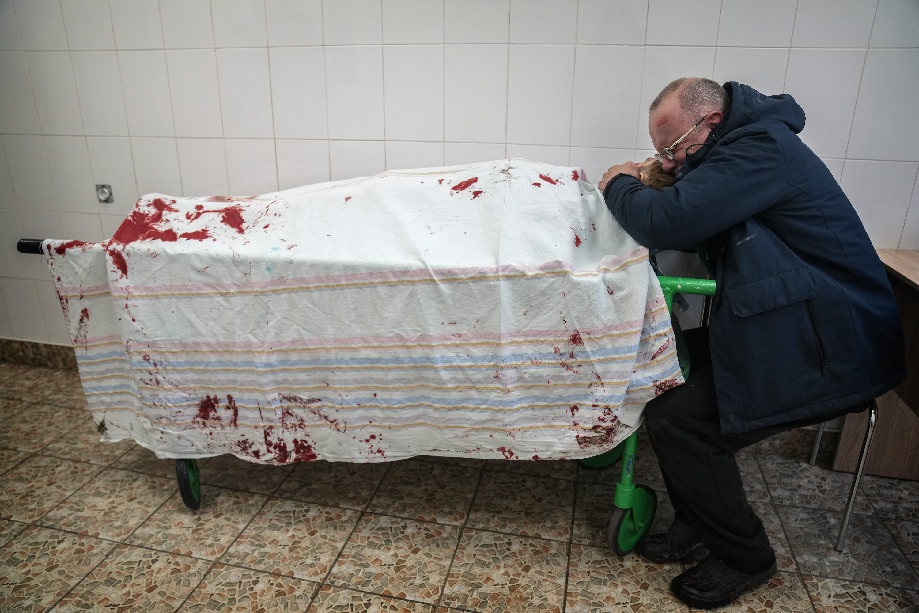 Сергій, батько підлітка Іллі, плаче над мертвим тілом свого сина, що лежить на ношах у пологовому будинку, переобладнаному під медичне відділення. Маріуполь, 2 березня 2022 року.