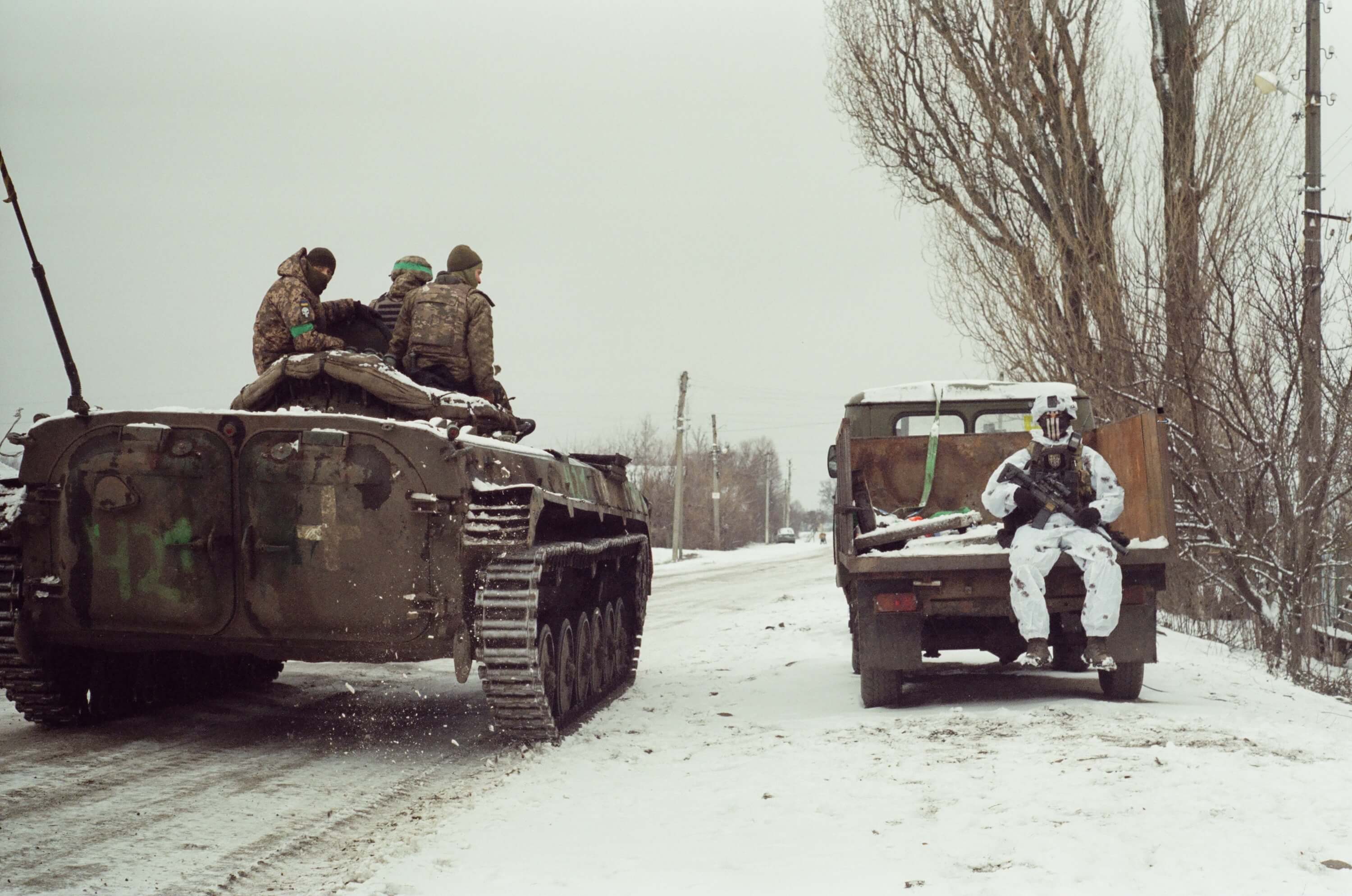 Мій побратим у маскувальному костюмі сидить навпроти українських військових на бронемашині.